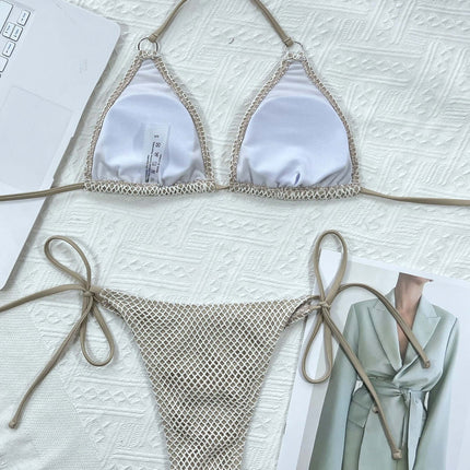 Bikini triangular blanco con lazos presentado sobre una superficie con un fondo texturizado.