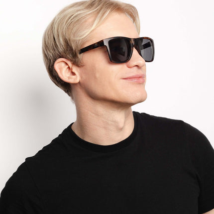 Hombre usando gafas de sol Hanukeii® Breezy Tortoise / Black, protegiéndose del sol con estilo.