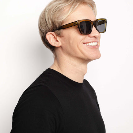 Hombre sonriendo con gafas de sol Hanukeii® Noosa Green / Black, mostrando estilo y protección UV400.