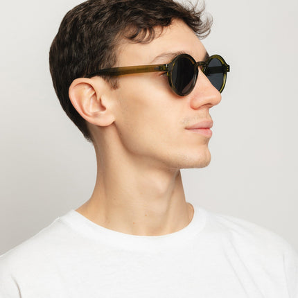 Gafas de sol Hanukeii® Harbor Green / Black en modelo masculino con luz natural, perfil derecho mostrando diseño moderno.